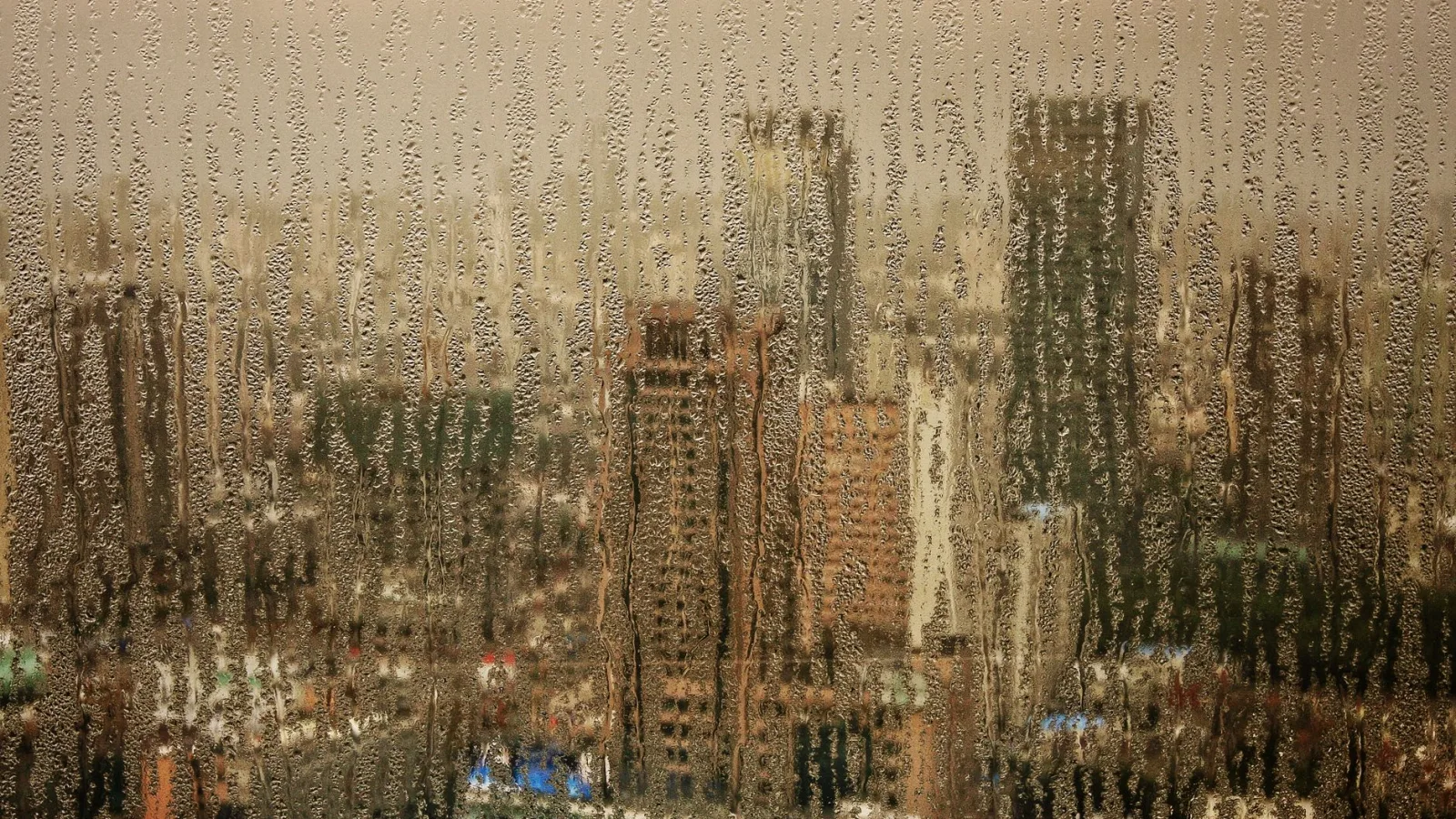 Rain-soaked window view of Shanghai's skyline, capturing an atmospheric urban scene.