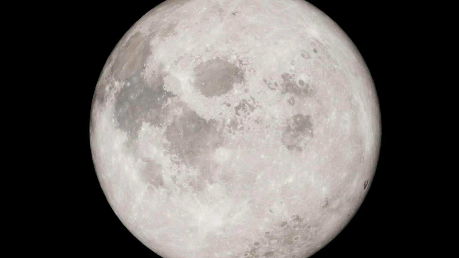 Detailed image of a full moon against a black night sky, showcasing lunar features.
