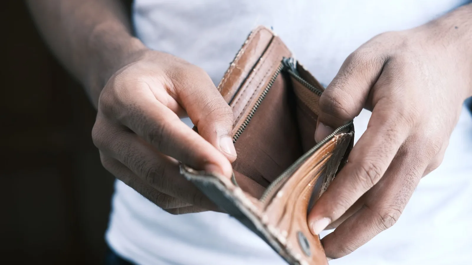 Close-up of hands holding an empty wallet, highlighting financial struggles and economic crisis.